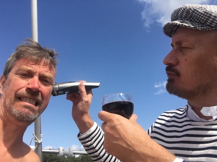 Morten og Kjell poserer for kamera samtidig som en av karene barberer den andre mens han holder et glass vin.