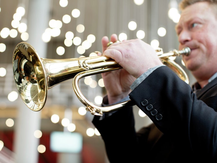 En mann spiller trompet.